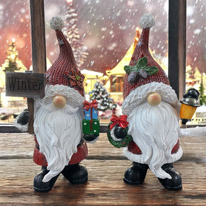 Formano Weihnachtswichtel mit Laterne und Geschenken vor winterlicher Kulisse mit Schnee und Lichtern.