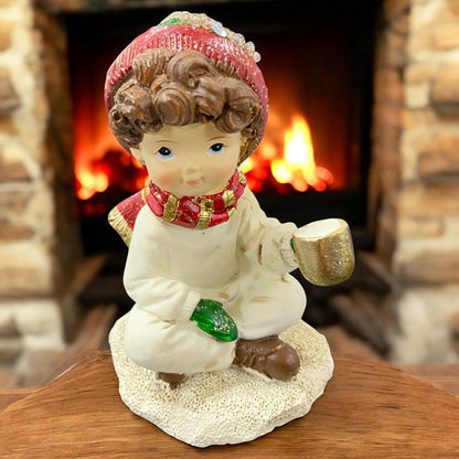 Formano Winterkind Junge mit roter Mütze und Schal, Dekofigur im gemütlichen Winterambiente vor Kamin.
