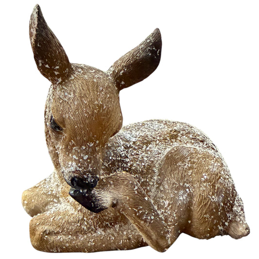 Ein liegendes Reh mit realistischer Fellstruktur ist mit feinem Kunstschnee bedeckt und wirkt wie in einer winterlichen Landschaft.