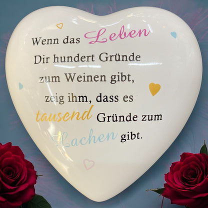 Deko Herz mit Spruch „Wenn das Leben dir hundert Gründe zum Weinen gibt, zeig ihm, dass es tausend Gründe zum Lachen gibt“ aus Keramik im Ambiente