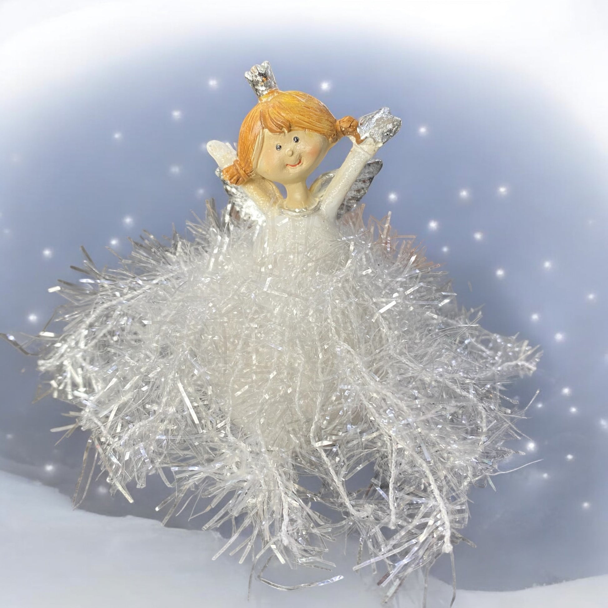 Engelchen mit einem Glitzerkleid und ausgestreckten Armen im Ambiente platziert.