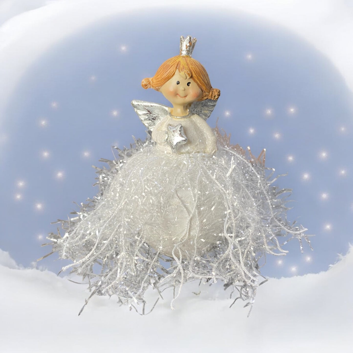 Engelchen mit einem Glitzerkleid und einem Stern haltend im Ambiente platziert