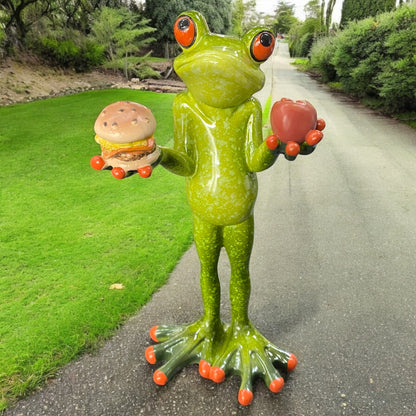 Ein Deko Frosch mit Burger und Apfel in Hand aus Kunststein der Serie Formano Froschhausen im Ambiente