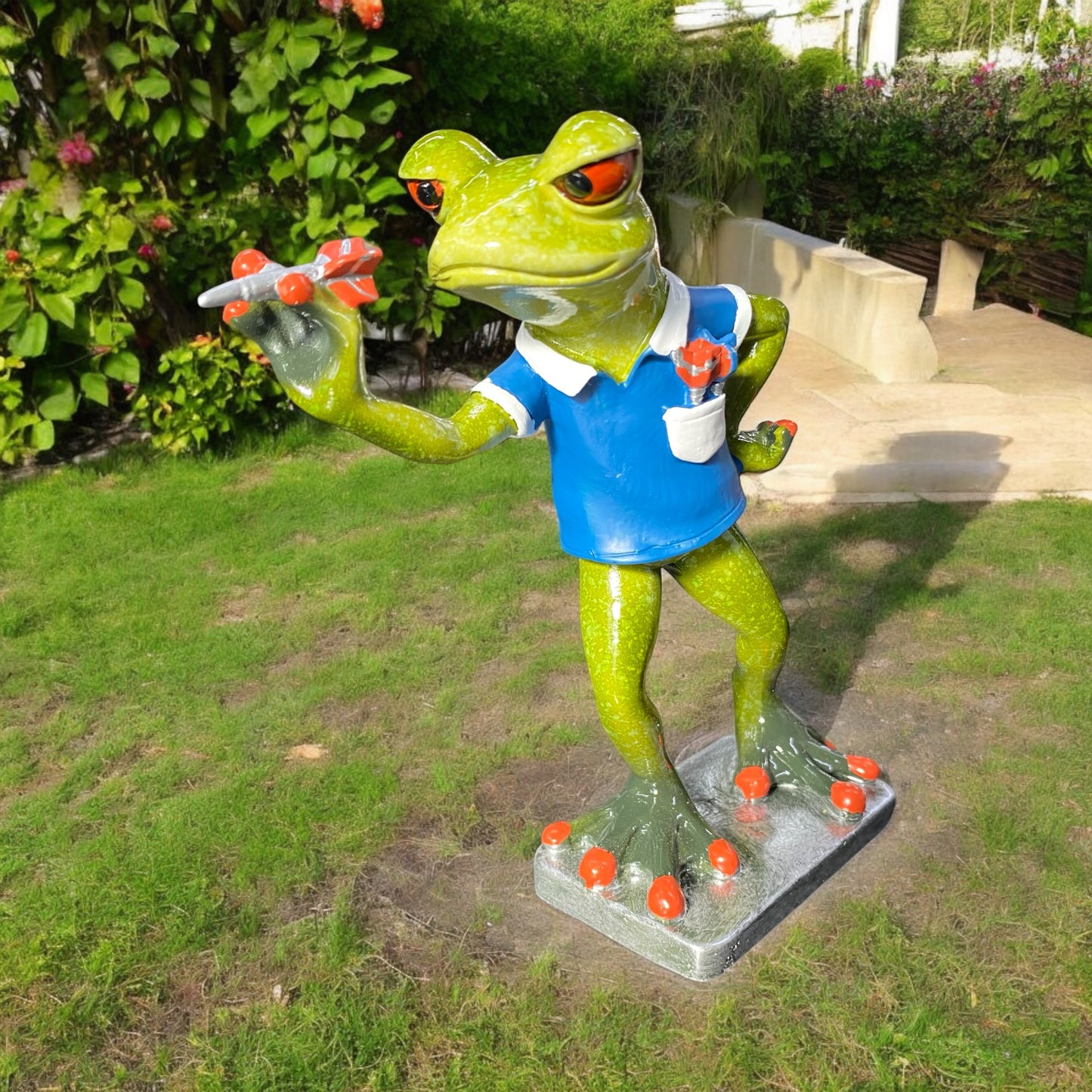 Eine Dekofigur im Ambiente, die einen Dart spielenden Frosch in blauem Trikot mit Dartpfeil abbildet.