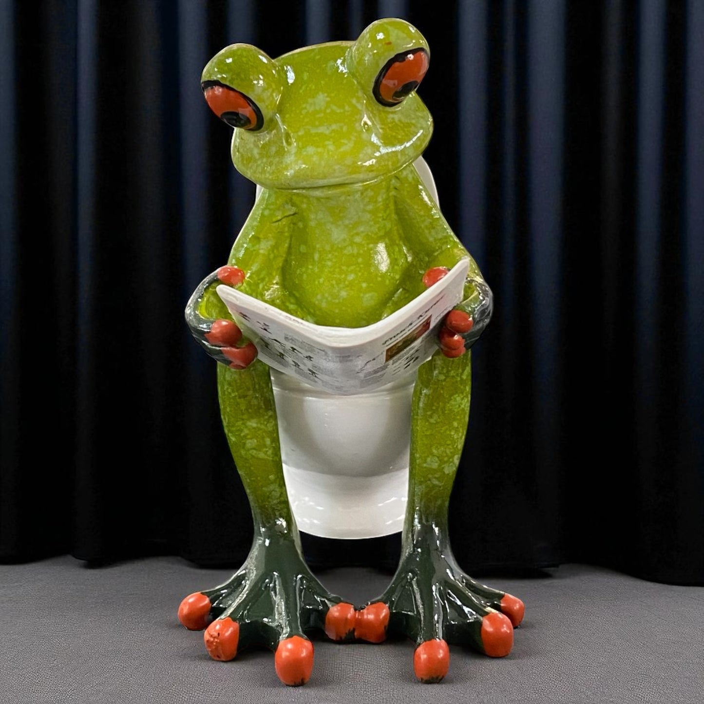 Formano Froschhausen Dekofigur Frosch auf Toilette mit Zeitung in der Hand im Ambiente frontale Ansicht