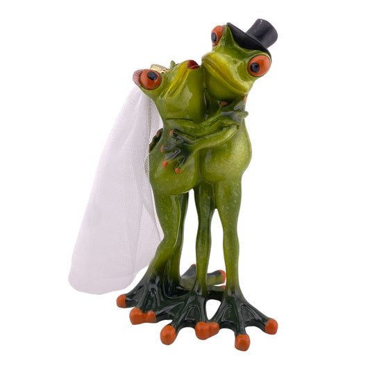 Eine Dekofigur vor weißem Hintergrund, die ein Frosch Brautpaar bei der Hochzeit abbildet. Die Froschdame trägt einen Schleier und der Froschbräutigamm einen Hut.