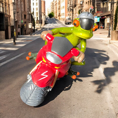 Ein Dekofigur Frosch der Serie Froschhausen sitzt auf einem rotem Motorrad und ist im Ambiente platziert.