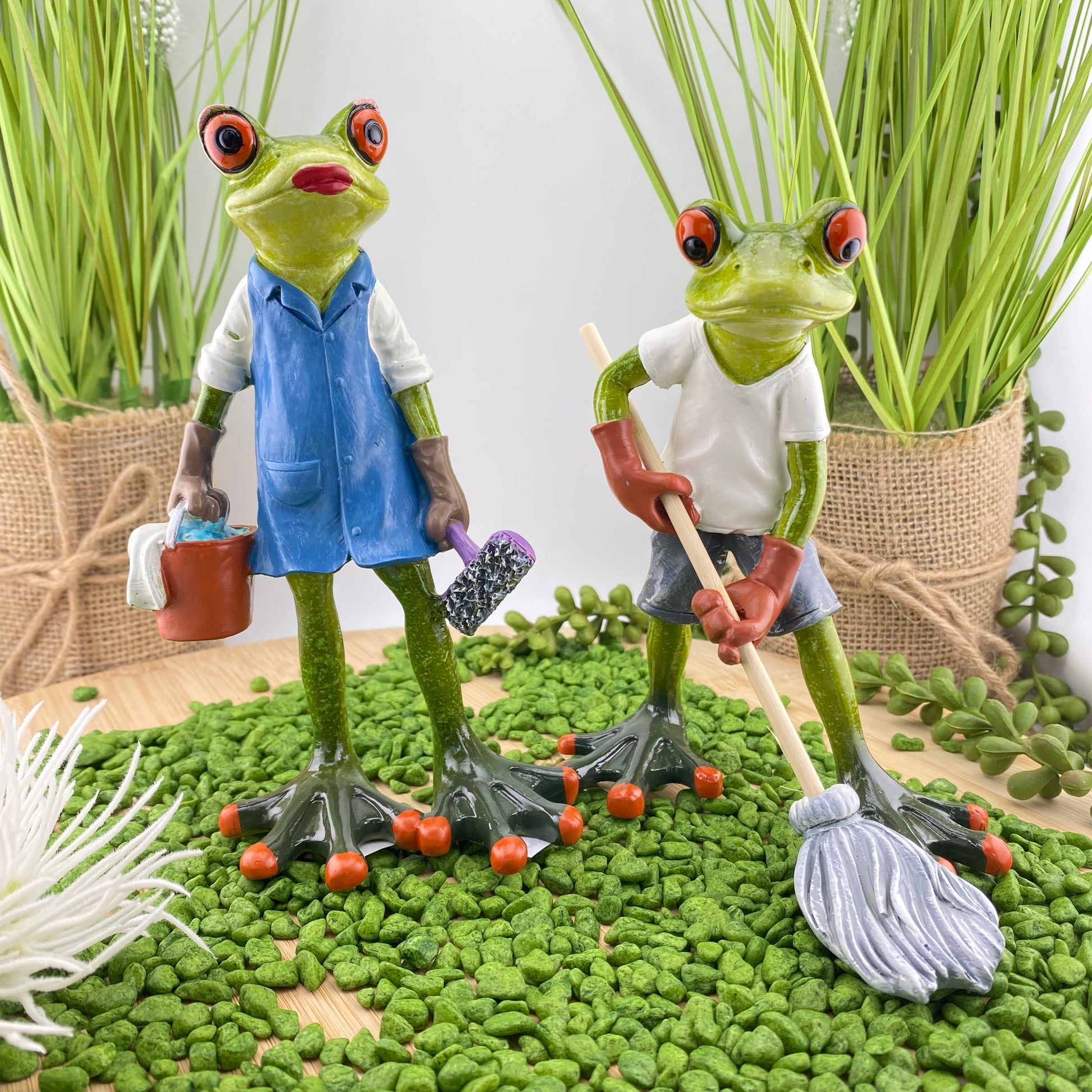 Eine Frosch Dekofigur Putzfrau und ein Deko Frosch Hausmeister der Serie Froschhausen sind im Ambiente platziert.