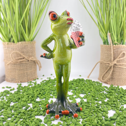 Ein weiblicher Dekofigur Frosch der Serie Froschhausen steht gemütlich mit einem Eis in der Hand im Ambiente.