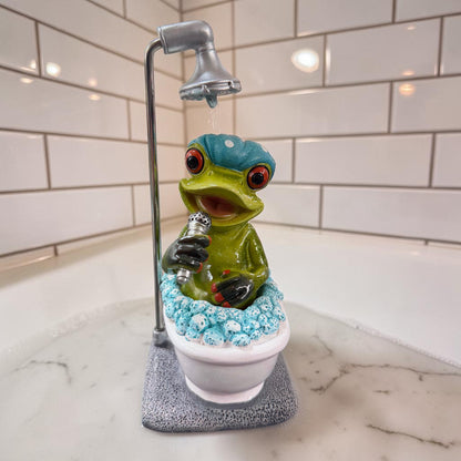 Grüner Formano Frosch mit blauer Badehaube und Mikrofon sitzt unter einer Dusche in einer weißen Badewanne vor weißen Fliesen.