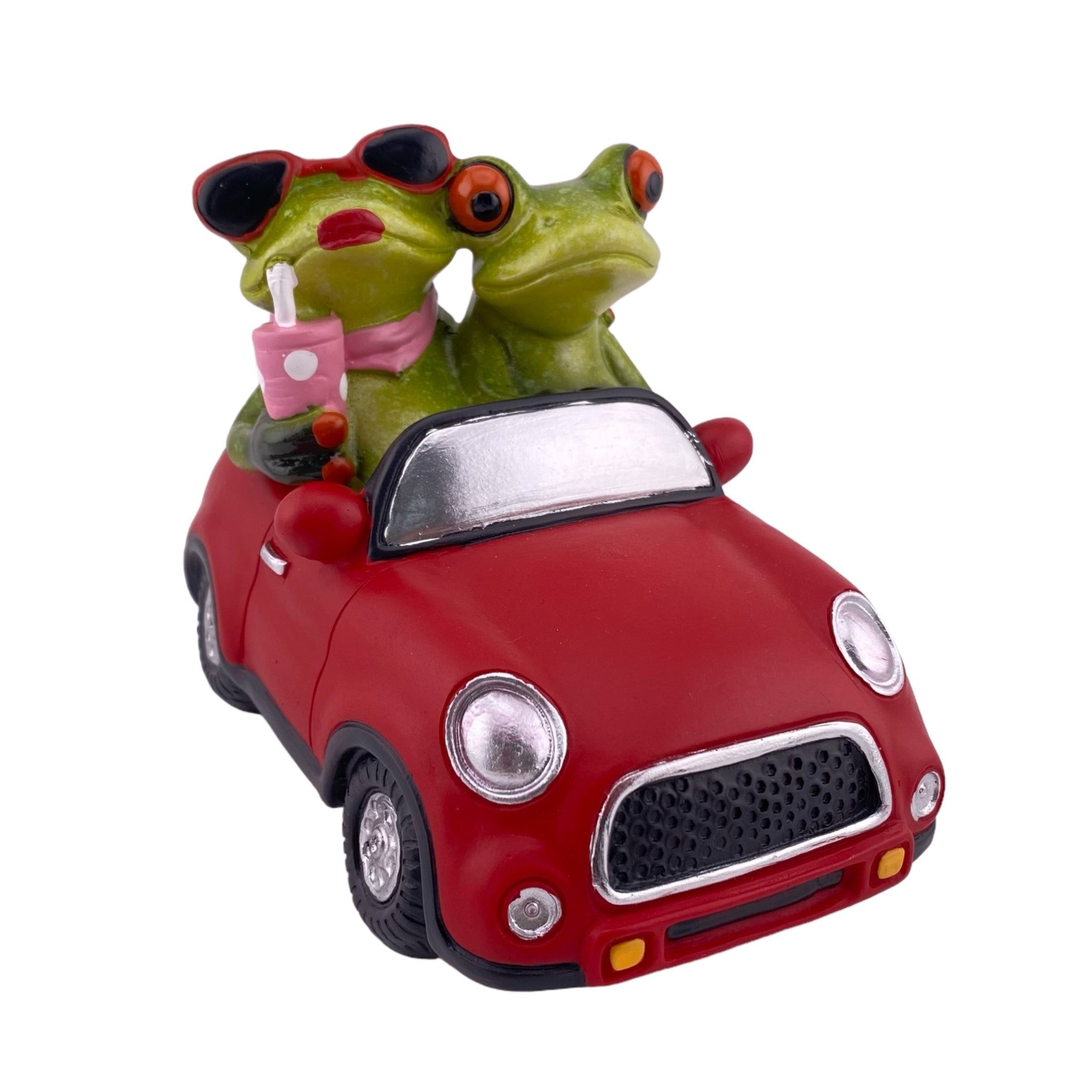 Ein Dekofigur Froschpaar der Serie Froschhausen sitzt in einem rotem Auto Cabrio. Die Frosch-Dame trägt eine Sonnenbrille und trinkt ein Kaltgetränk. Der Frosch-Mann fährst das Auto. Die Frosch-Dekofigur ist vor weißem Hintergrund platziert.