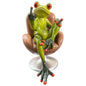 Grüner Formano Frosch sitzt mit Zigarre und erhobenem Mittelfinger in einem braunen Drehsessel vor weißem Hintergrund