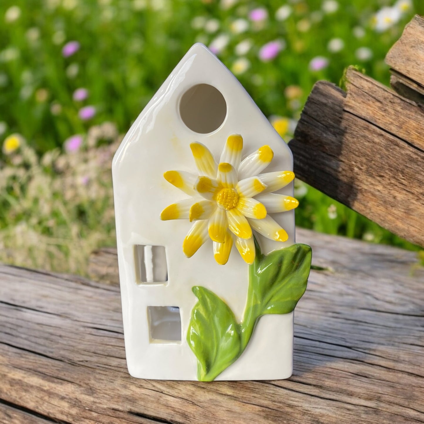 Keramik Haus in weiß mit gelber Blume für ein Teelicht im Ambiente platziert