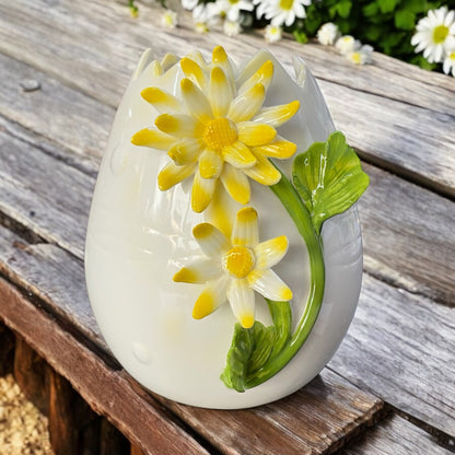 Keramik Vase in weiß mit gelber Blume im Ambiente platziert