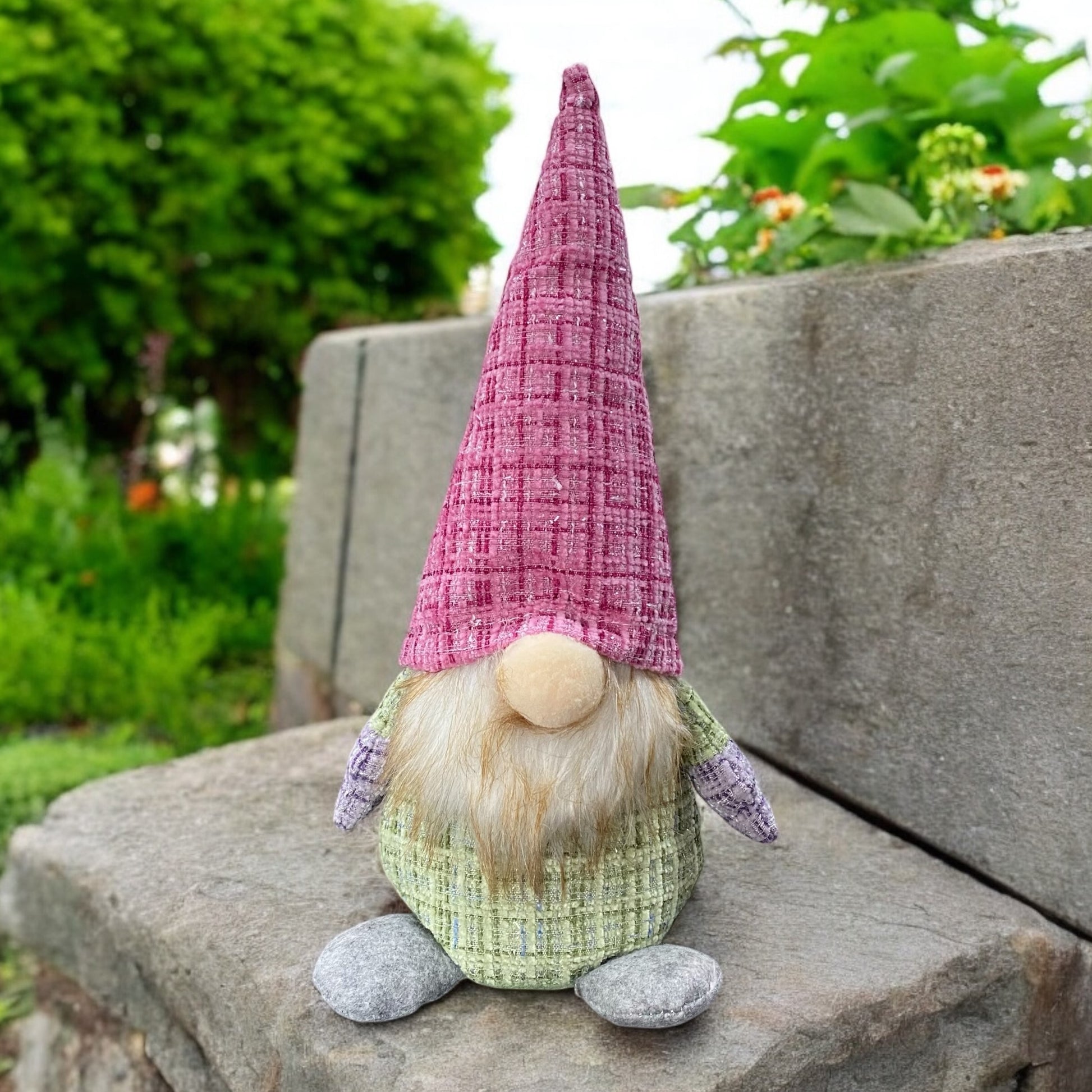 Ein großer Deko Stoff Wichtel zum Aufstellen mit pinker Zipfelmütze und grünem Körper im Ambiente