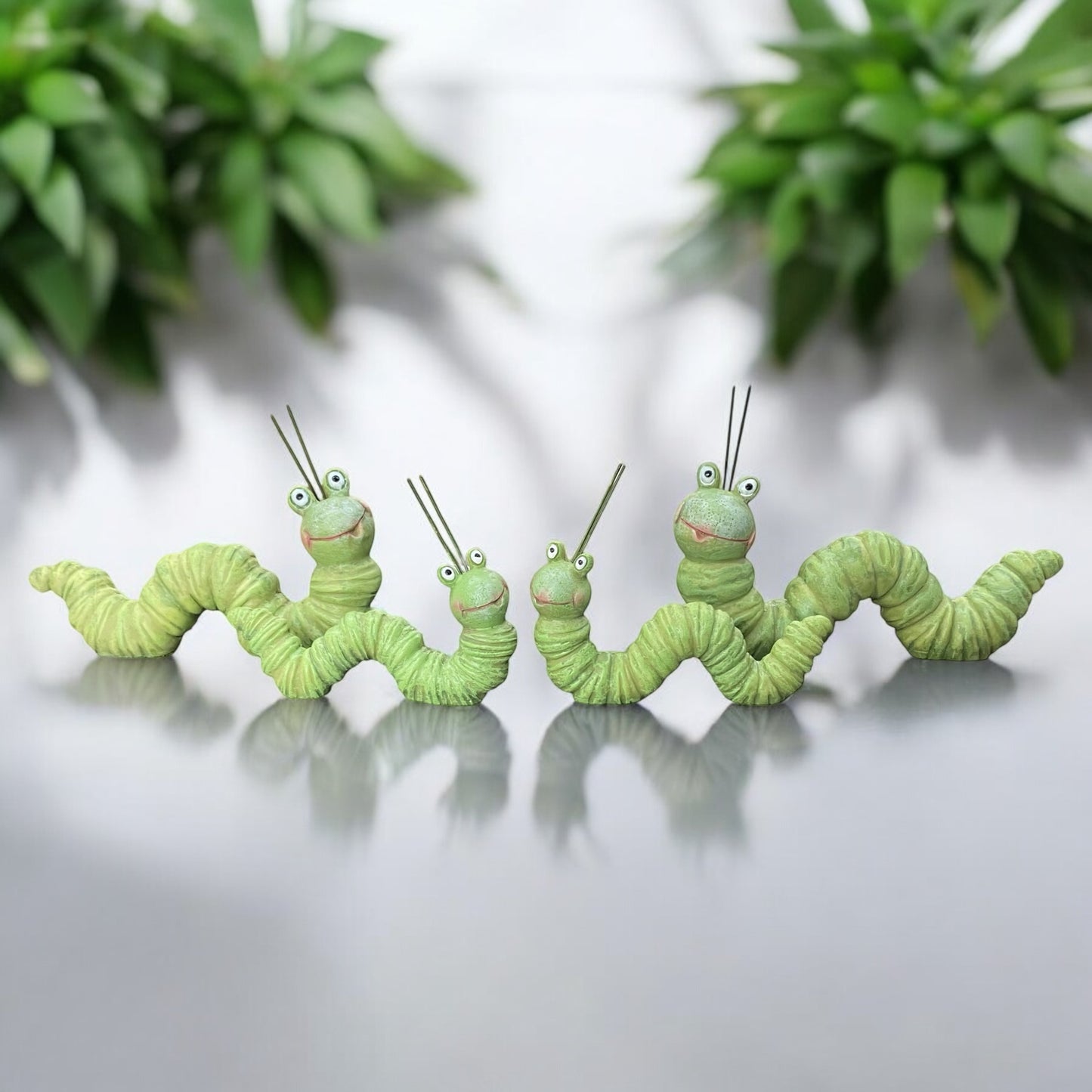 Vier grüne Dekofigur Raupen mit fröhlichem Gesicht im Ambiente
