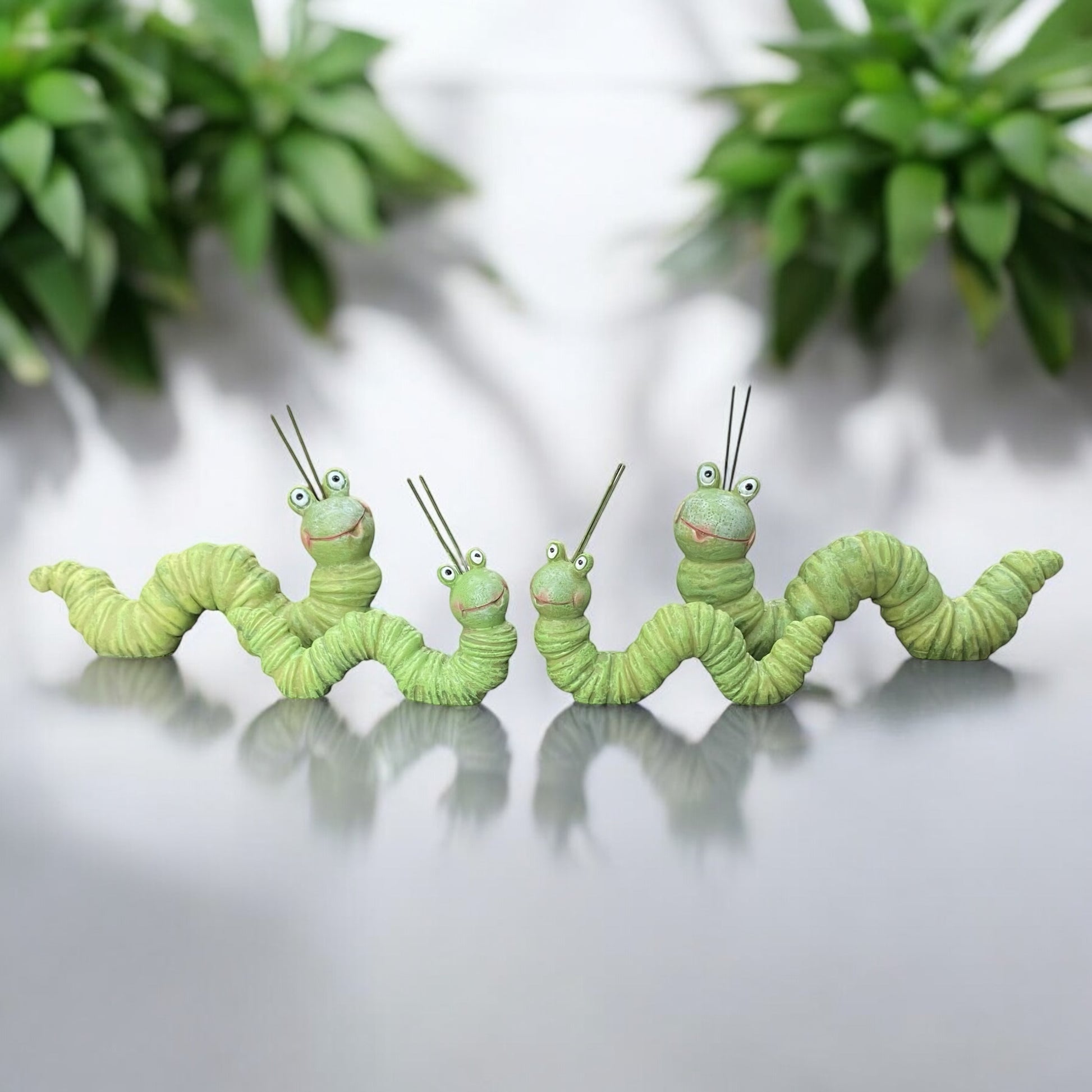 Vier grüne Dekofigur Raupen mit fröhlichem Gesicht im Ambiente

