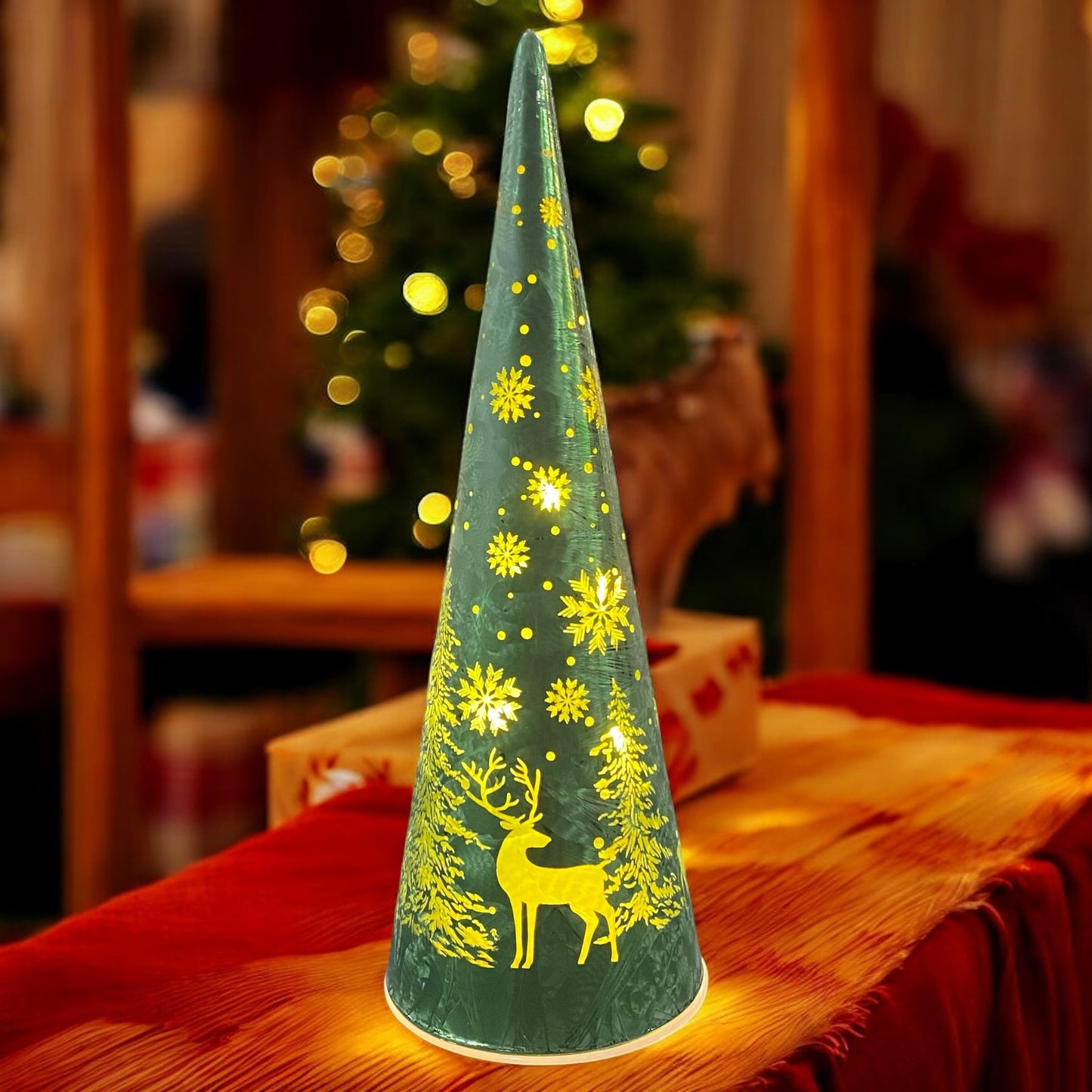 Kleiner grüner LED-Glastannenbaum von Formano mit leuchtendem Hirschmotiv, festlich auf Tisch im warmen Licht dekoriert.