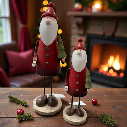 Zwei stehende Nikolausfiguren aus Holz in unterschiedlichen Größen stehen dekorativ vor einem Kamin und sorgen für eine gemütliche Weihnachtsstimmung.