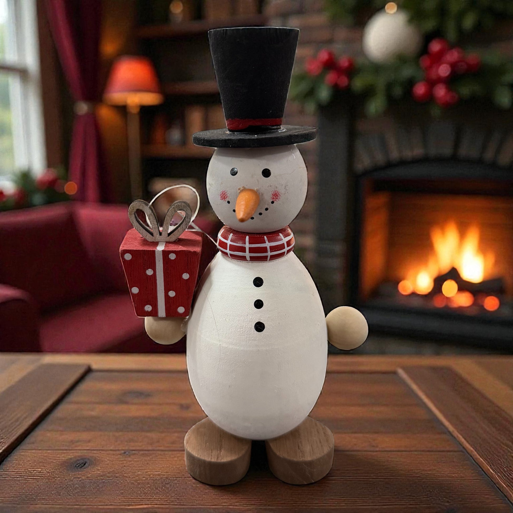 Ein dekorativer Holz-Schneemann mit Zylinder und Geschenk wird stimmungsvoll vor einem Kamin präsentiert.