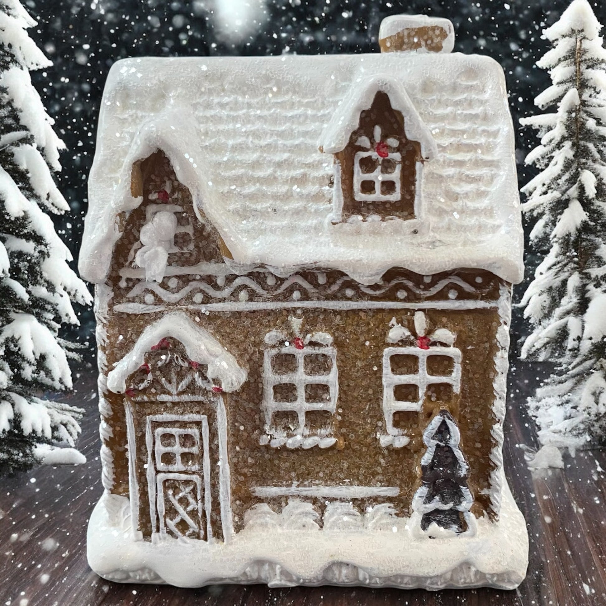 Formano Lebkuchenhaus mit LED-Beleuchtung, stimmungsvoll im Schnee mit Tannenbäumen dekoriert.