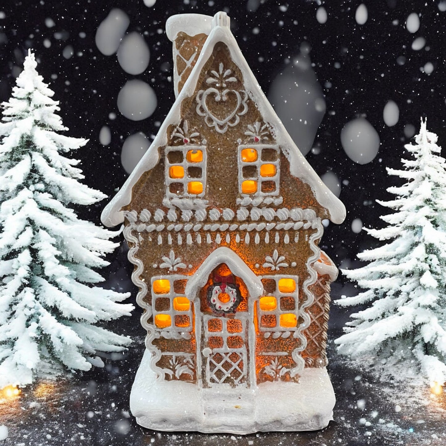 Formano Lebkuchenhaus mit eingeschalteter LED-Beleuchtung, winterliche Schneeszene mit Tannen.