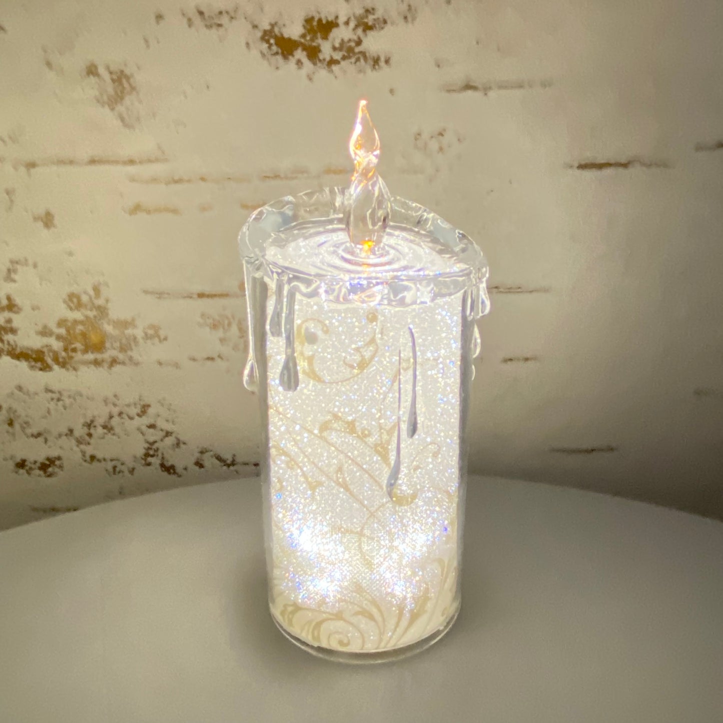 Mittlere Acryl Kerze mit goldenen Ornamenten im Ambiente beleuchtet