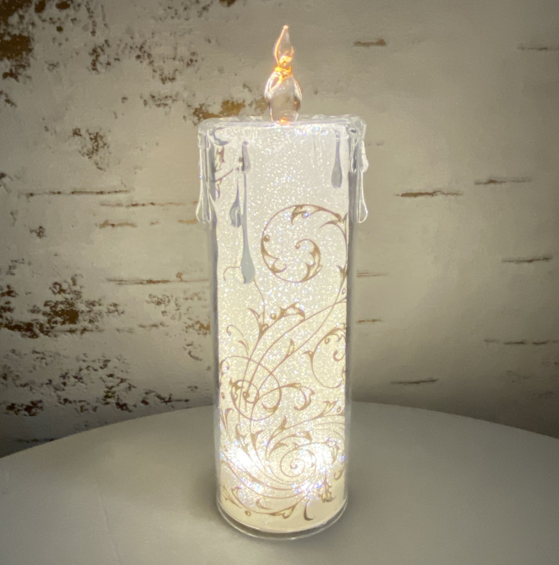 Große Acryl Kerze mit goldenen Ornamenten im Ambiente beleuchtet