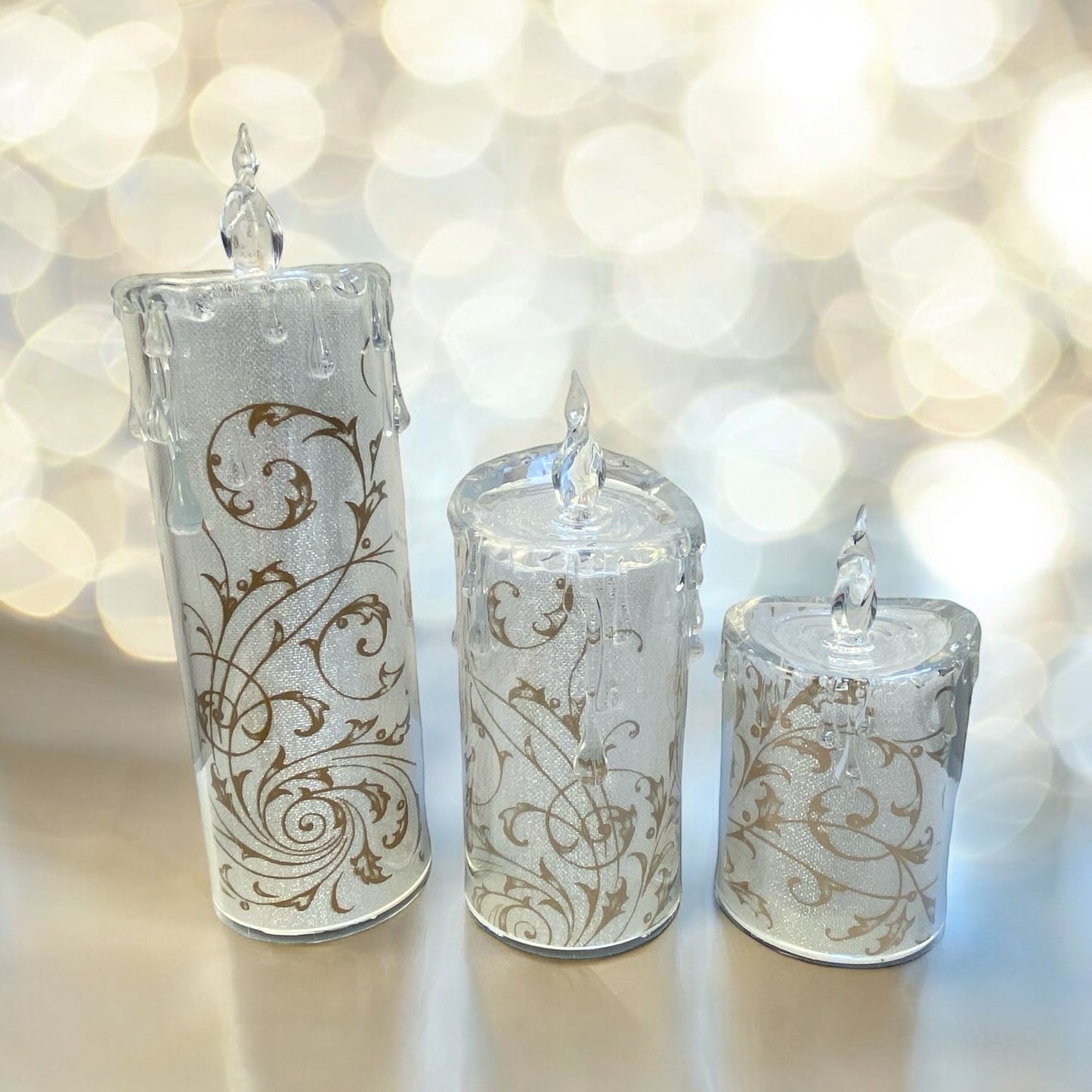 Acryl Kerzen mit goldenen Ornamenten in drei verschiedenen Größen im Ambiente platziert