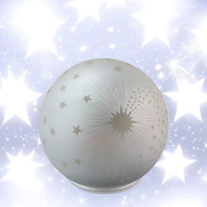 Leuchtende silberne Deko-Kugel mit Sternenmotiv auf hellem Hintergrund voller funkelnder Sterne