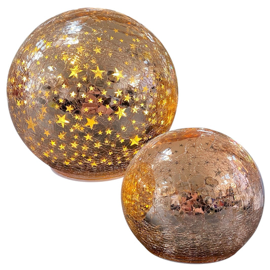 Zwei rosa LED-Deko-Kugeln aus Crackle-Glas mit leuchtenden goldenen Sternmotiven in unterschiedlichen Größen.