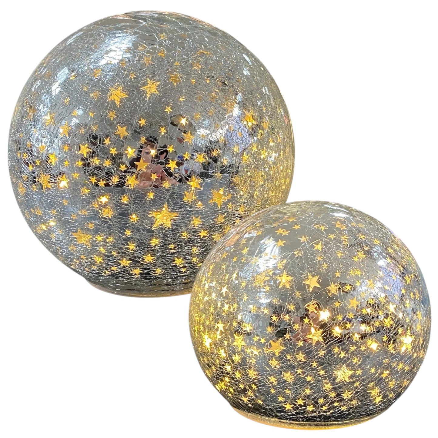 Zwei silberne LED-Deko-Kugeln aus Crackle-Glas mit leuchtenden goldenen Sternmotiven in unterschiedlichen Größen.