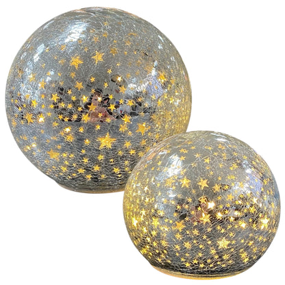 Zwei silberne LED-Deko-Kugeln aus Crackle-Glas mit leuchtenden goldenen Sternmotiven in unterschiedlichen Größen.