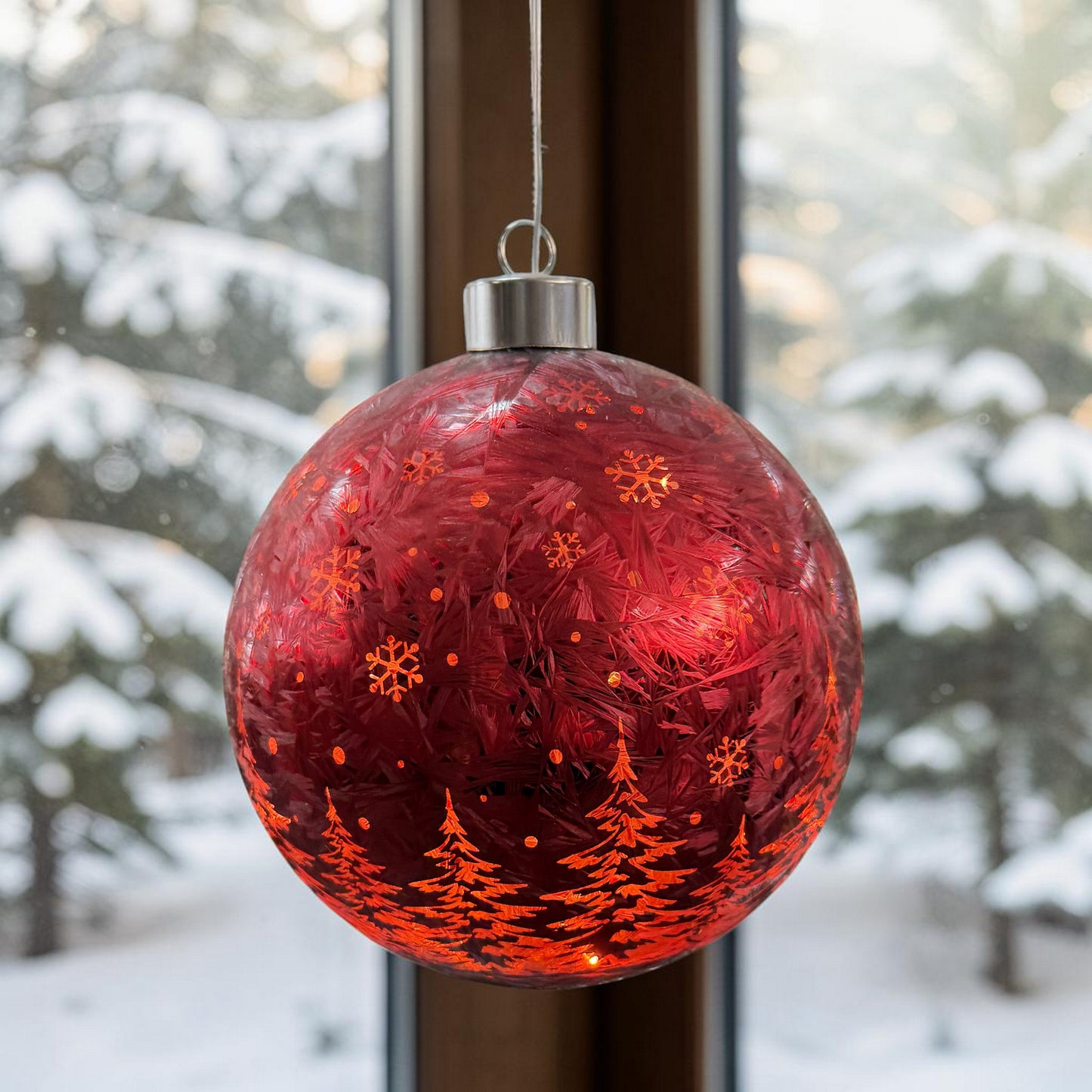 Rote Kugelleuchte mit strukturierter Oberfläche und winterlichen Motiven auf hellem Hintergrund.