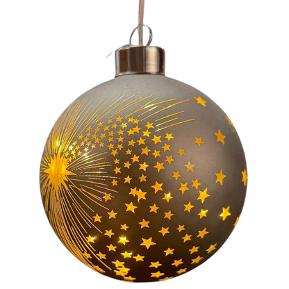 Eine taupefarbene LED-Dekokugel mit Sternschnuppen- und Sternenmotiv zeigt ein durchbrochenes Design mit Licht im Inneren.
