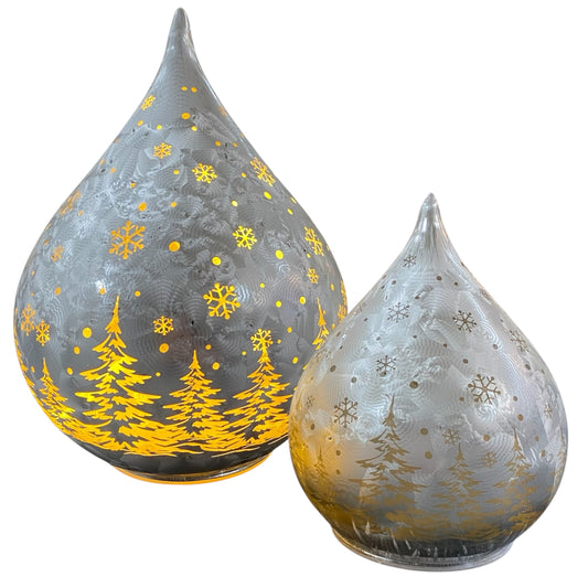 Zwei silberne LED-Deko-Tropfen mit goldener Winterlandschaft und Schneeflockenmotiv in unterschiedlichen Größen.