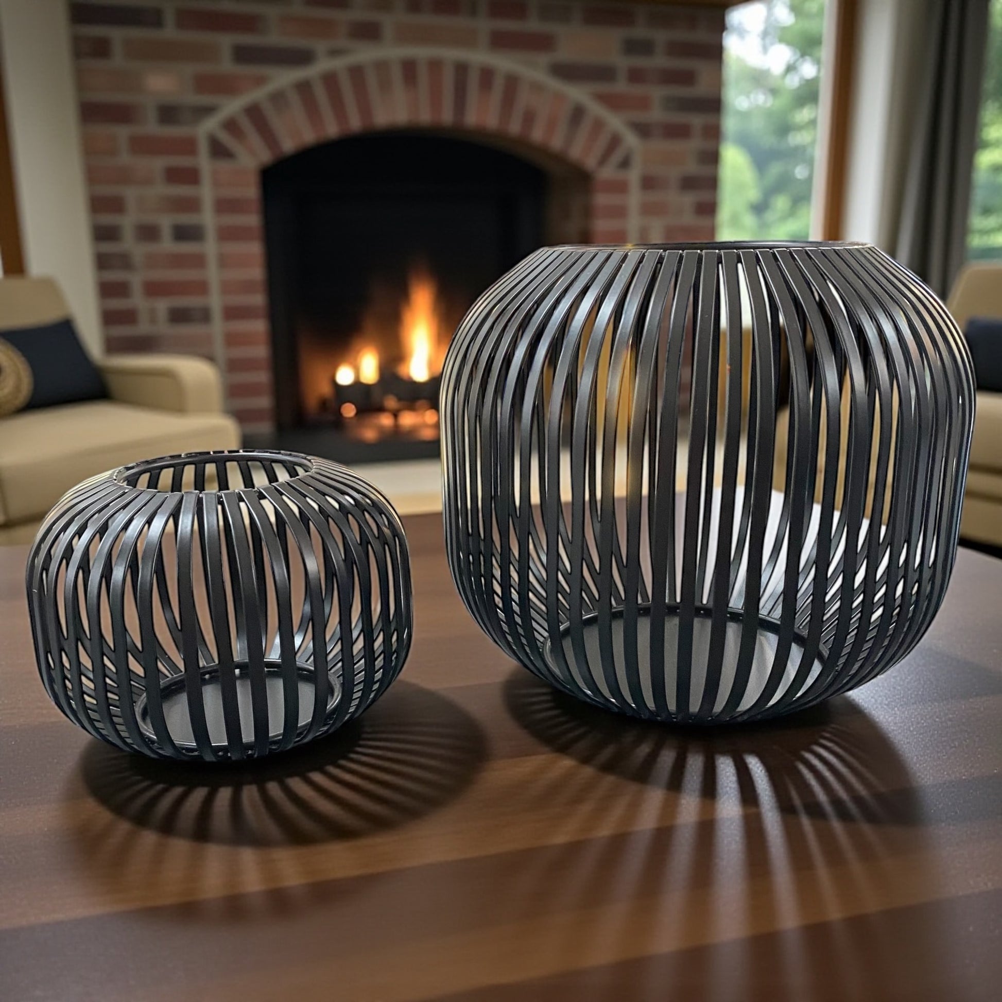 Zwei schwarze Formano Metall-Windlichter in modernem Streifendekor, stimmungsvoll vor Kamin arrangiert.