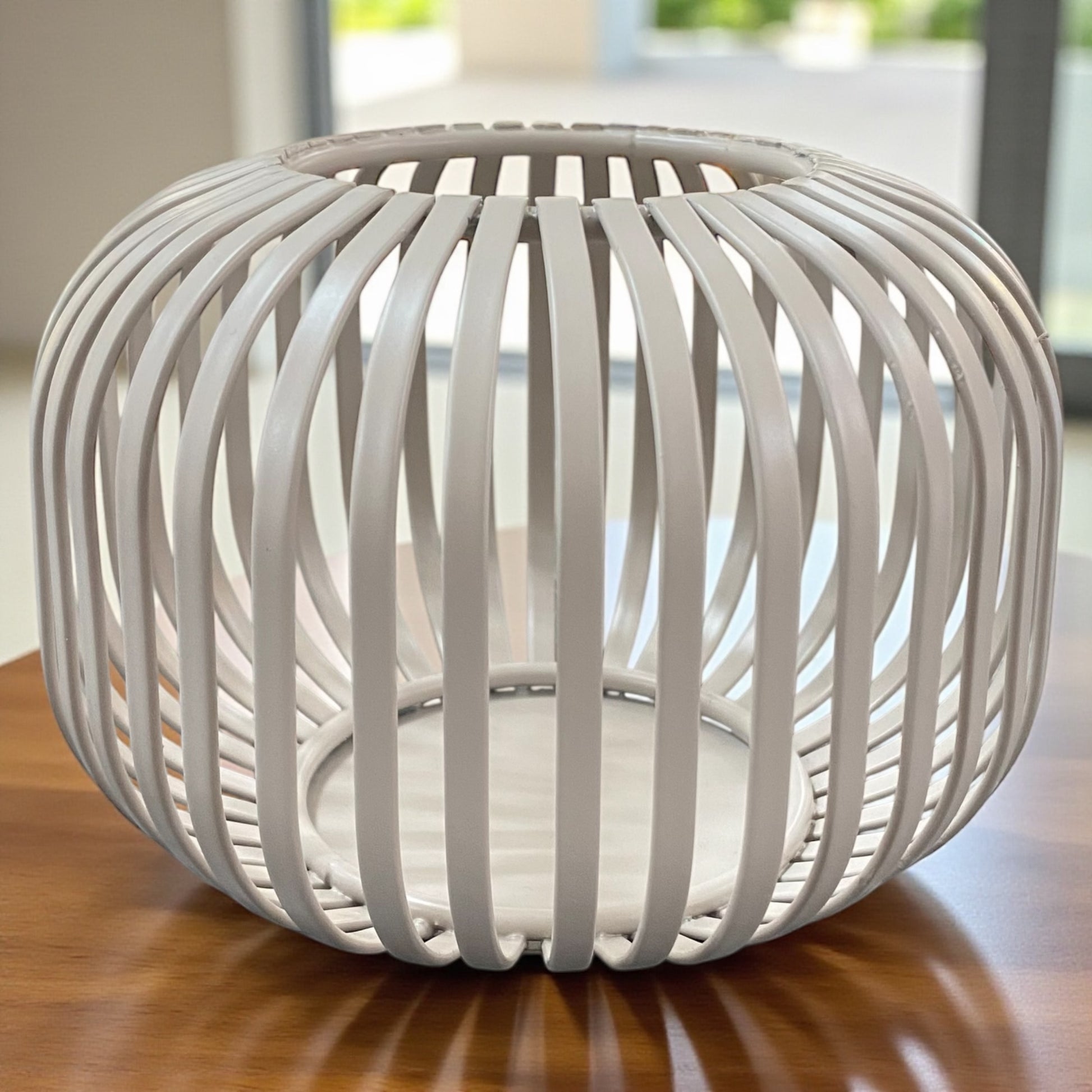 Kleines Formano Windlicht aus taupe-farbenen Metall mit dekorativer Strebenoptik, auf Tisch platziert