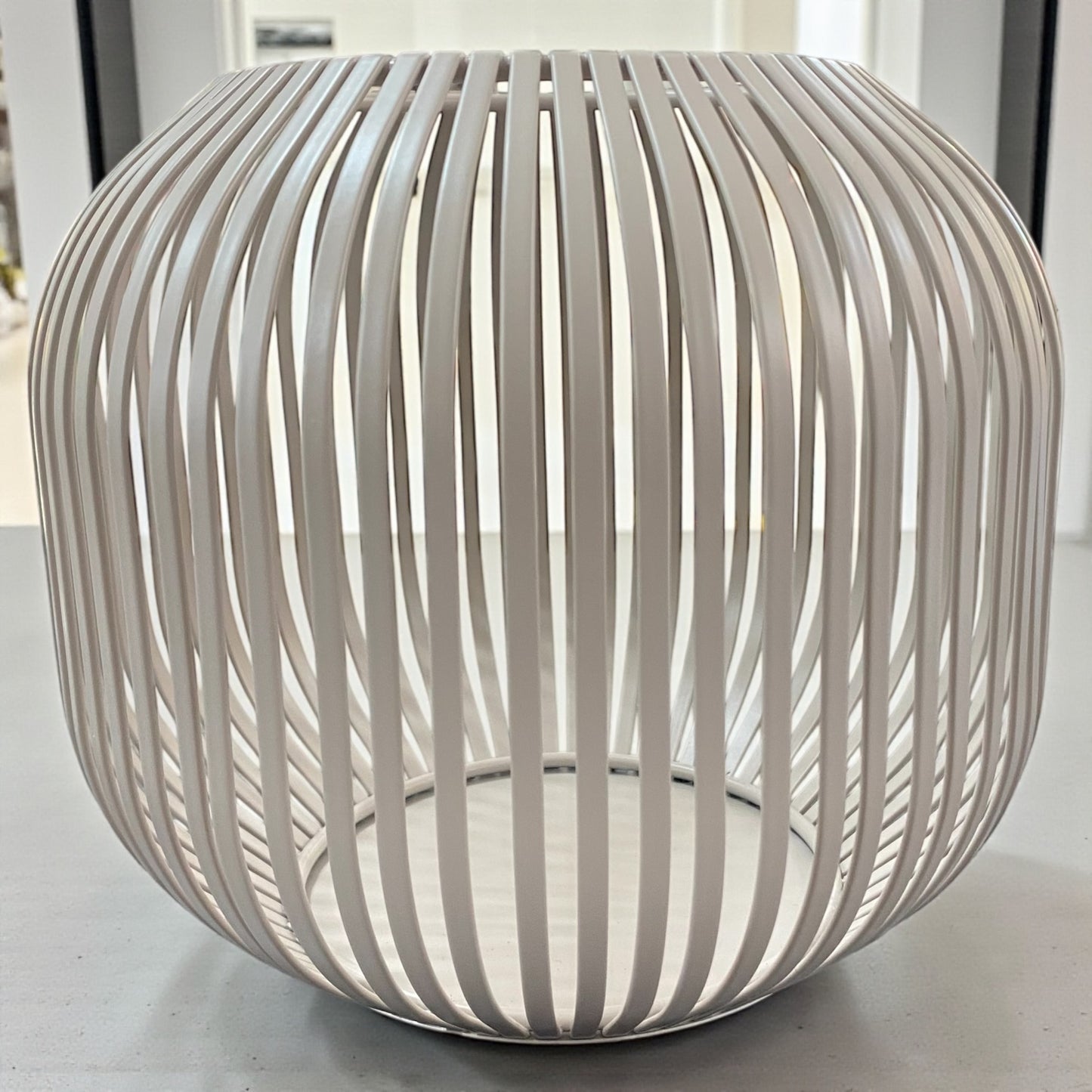 Formano Windlicht aus taupe-farbenen Metall mit dekorativer Strebenoptik, auf Tisch platziert