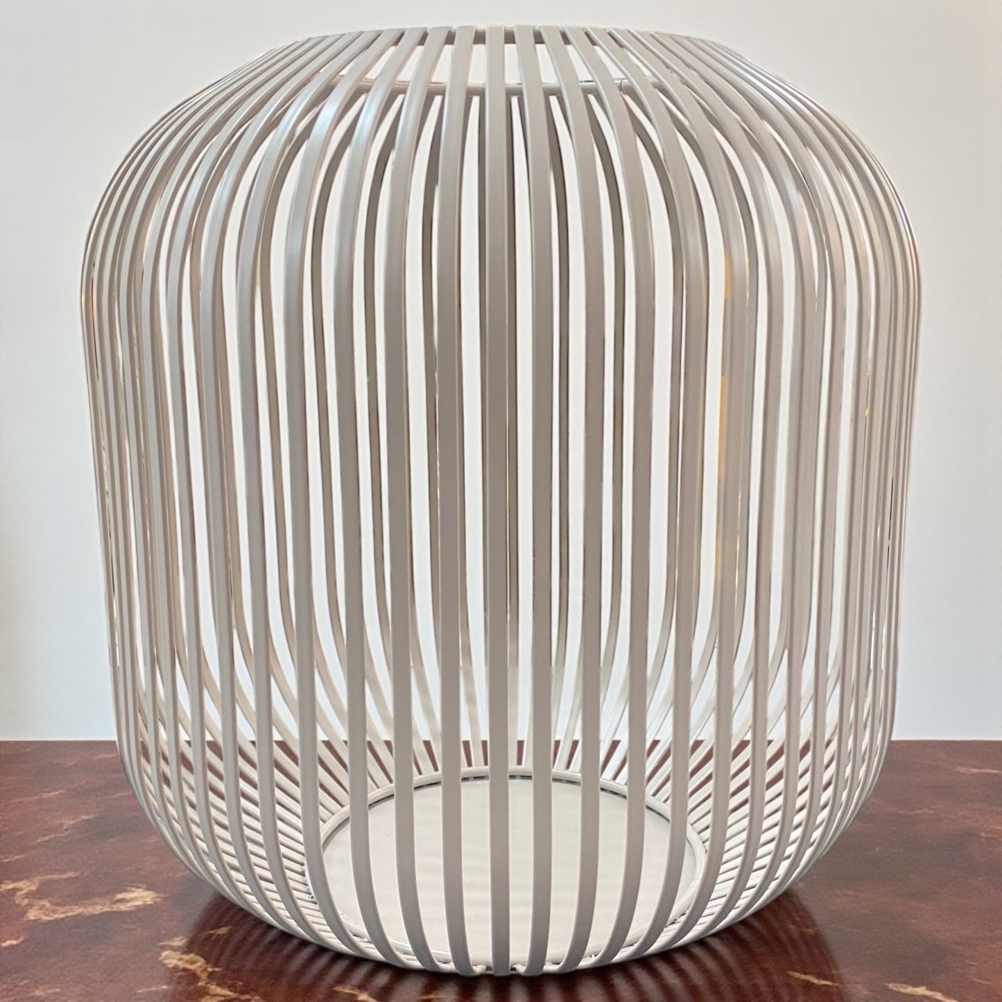 Großes Formano Windlicht aus taupe-farbenen Metall mit dekorativer Strebenoptik, auf Tisch platziert