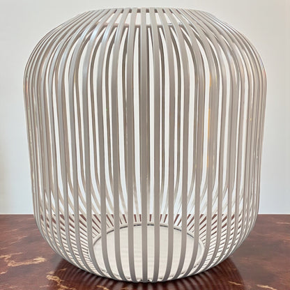 Großes Formano Windlicht aus taupe-farbenen Metall mit dekorativer Strebenoptik, auf Tisch platziert