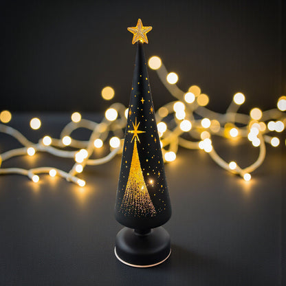 Moderne LED-Dekosäule in Tannenbaumform in Schwarz mit filigranen Stern- und Lichtpunkten, stimmungsvoll beleuchtet vor warmem Lichterketten-Hintergrund.