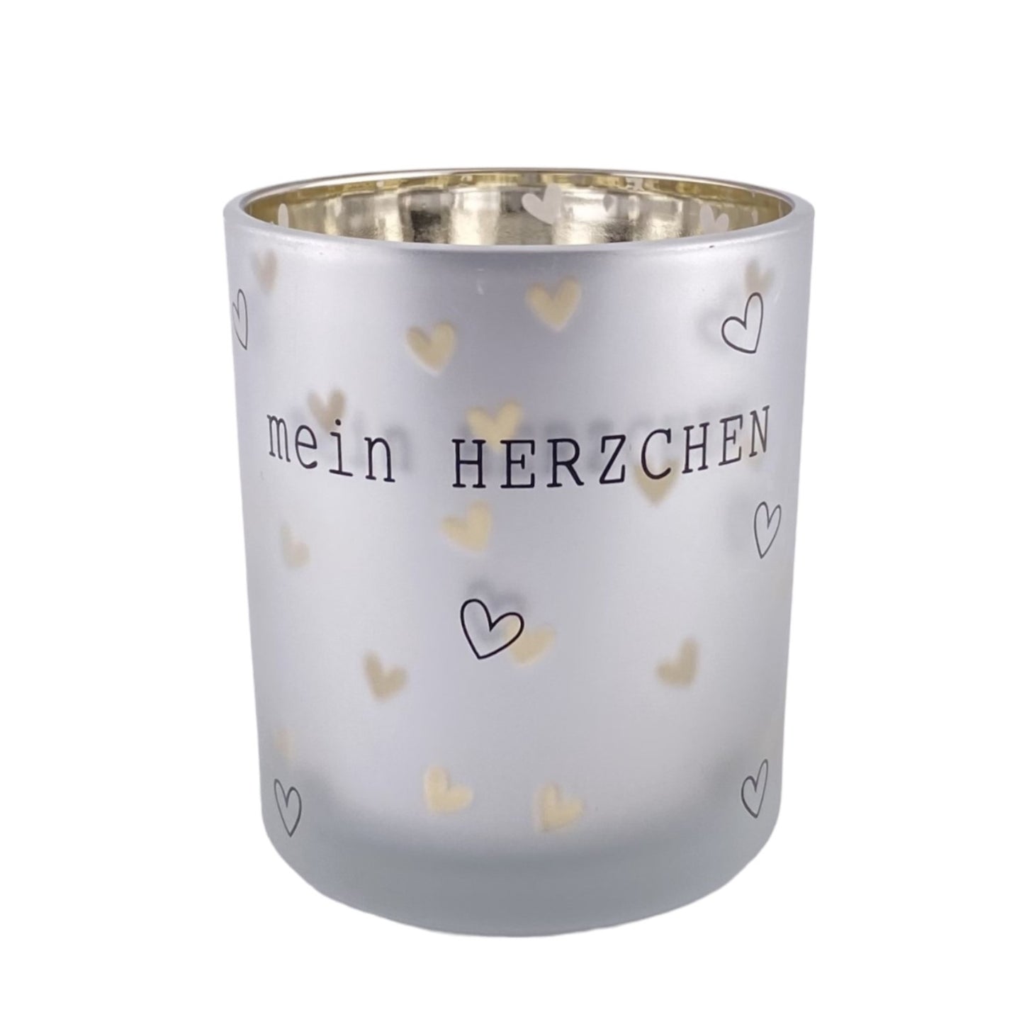 Ein silberner Teelichthalter aus Glas mit Schriftzug "mein HERZCHEN" und kleinen schwarzen und silbernen Herzen. Die Innenseite des Teelichts ist gold.