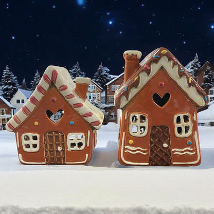 Zwei braune Formano Lebkuchenhaus Windlichter aus Keramik, festlich im Schnee dekoriert.