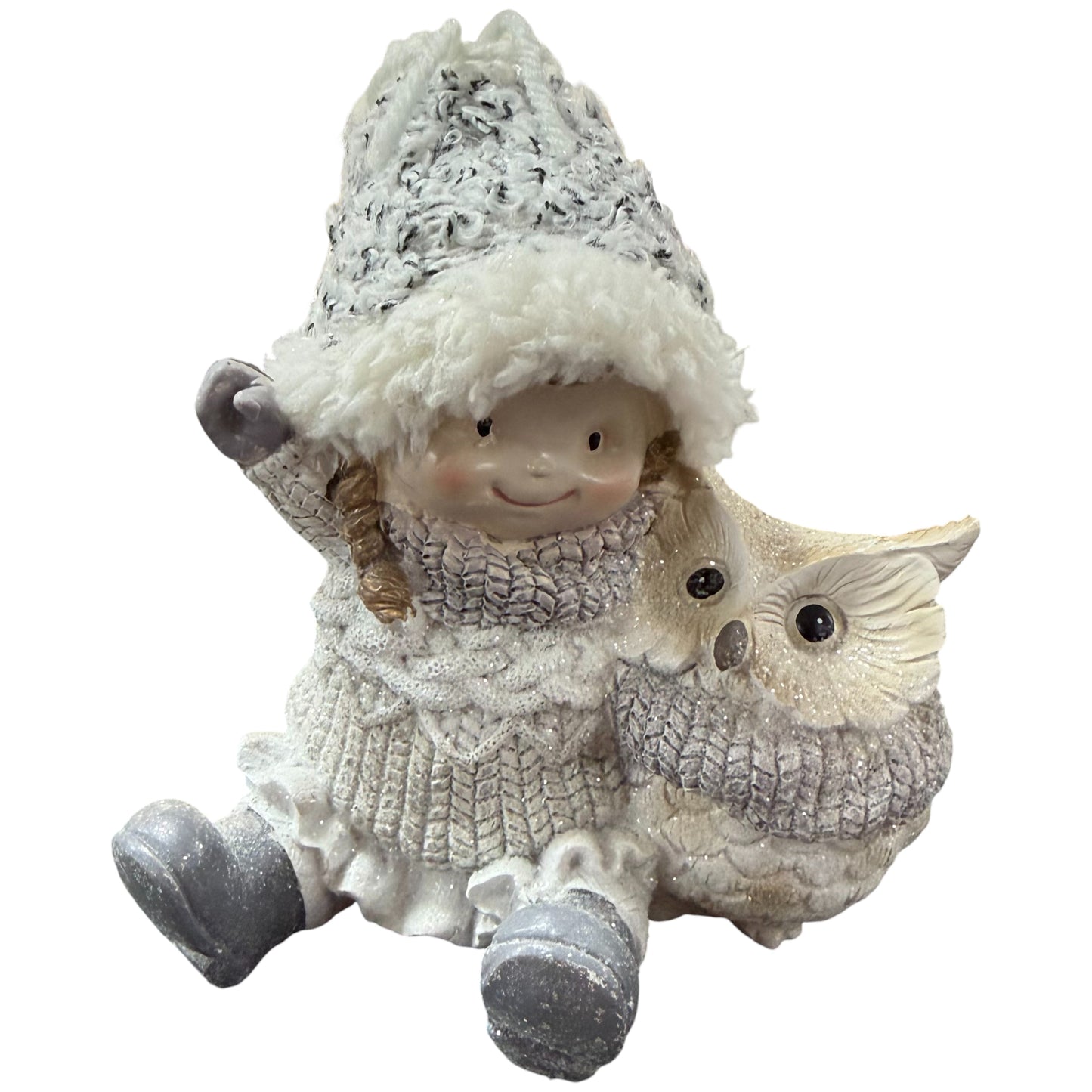 Keramikfigur zeigt ein sitzendes Mädchen mit Winterkleidung und Mütze neben einer Eule.