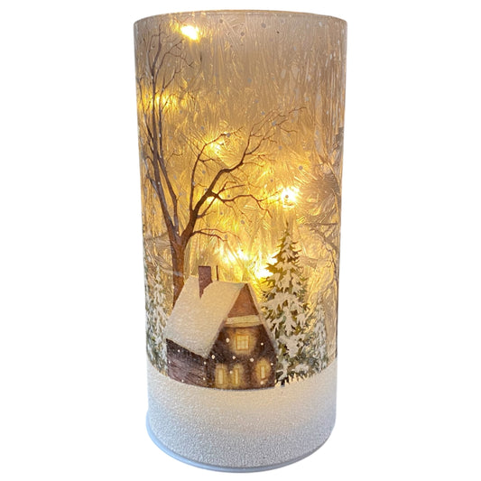 Zylindrisches LED-Licht mit winterlicher Hüttenszene, Tannenbäumen und Schneelandschaft in warmem Licht.
