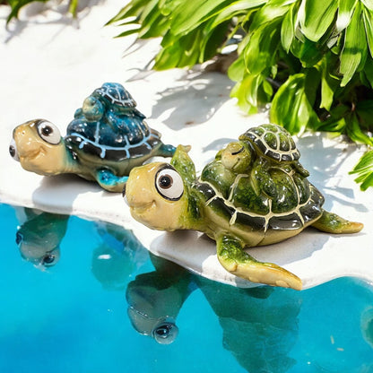 Zwei Keramik Deko-Schildkröten grün und blau mit Baby auf dem Rücken liegend im Ambiente