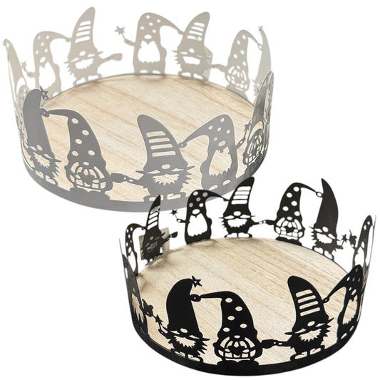 Ein rundes Dekotablett mit hellem Holzboden und filigranem Metallrand zeigt umlaufende Wichtel-Silhouetten in Schwarz und Weiß als verspieltes, winterliches Design.