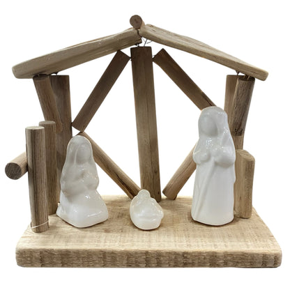 Schlichte Weihnachtskrippe aus Holz mit weißen Keramikfiguren von Maria, Josef und Jesuskind.