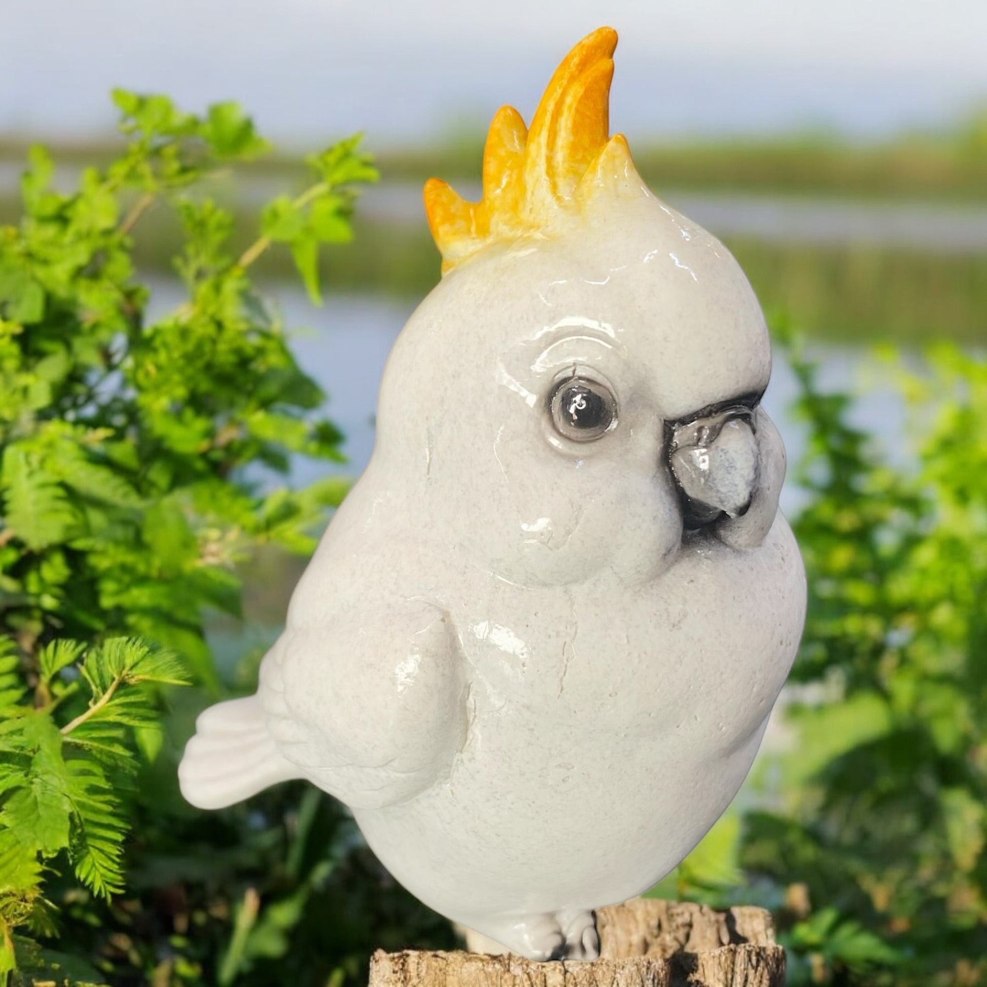 Creme-weiße Dekofigur Kakadu aus Kunststein von Gilde mit orangefarbener Federkrone im Ambiente